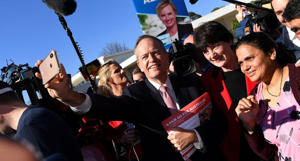 Australian Labor leader Bill Shorten takes a selfie with supporters.