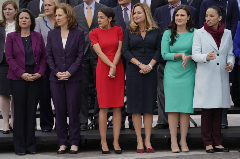 In this Nov. 14, 2018 photo, from l-r., Rep.-elect Angie Craig, D-Minn., Rep.-elect Kim Schrier, D-WA., Rep.-elect Alexandria Ocasio-Cortez, D-NY., Rep.-elect Debbie Mucarsel-Powell, D-Fla., Rep.-elect Abby Finkenauer, D-Iowa, and Rep.-elect Sharice Davids, D-KS., line up as they join other members of the freshman class of Congress for a group photo on Capitol Hill in Washington. (AP Photo/Pablo Martinez Monsivais)