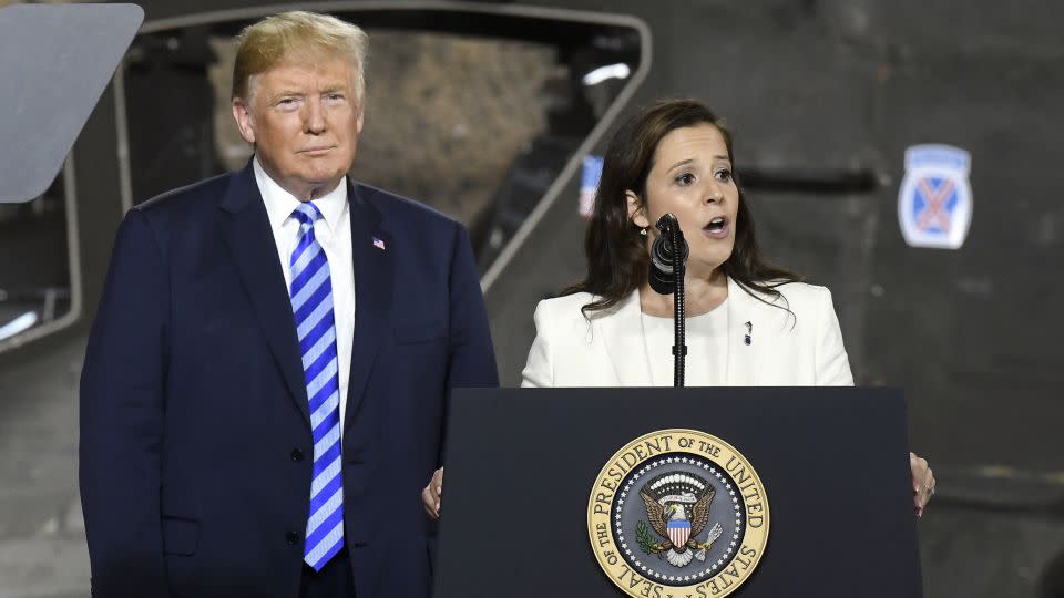 In this August 13, 2018 file photo, then-President Donald Trump, left, listens as Rep. Elise Stefanik speaks at an event at Fort Drum, New York. - Hans Pennink/AP