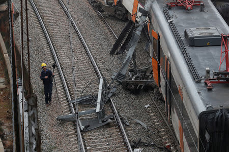 A worker investigates the scene after a commuter train derailed between Terrassa and Manresa, outside Barcelona, Spain, November 20, 2018. REUTERS/Albert Gea