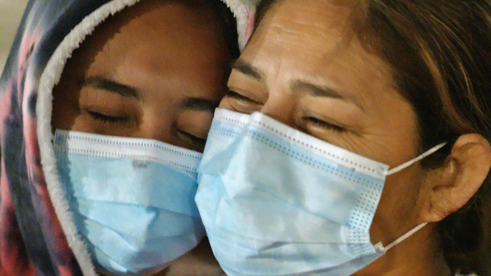 Cindy, an unaccompanied teen from Honduras, left, is reunited with her mother after the teen was hospitalized with Covid-19. (P.J. Tobia / NBC News)