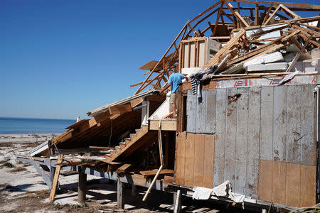 People clean up their house that was destroyed following Hurricane Michael in Mexico Beach, Florida, U.S., October 13, 2018. REUTERS/Carlo Allegri