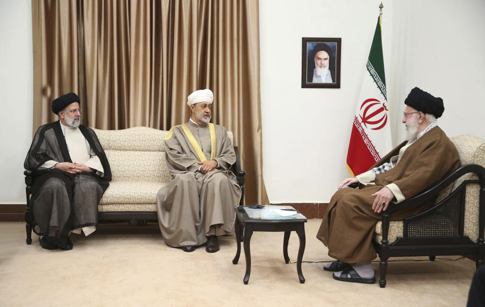 In this picture released by the office of the Iranian supreme leader, Supreme Leader Ayatollah Ali Khamenei, right, meets with Oman's Sultan Haitham bin Tariq Al Said, center, as Iranian President Ebrahim Raisi sits at left, in Tehran, Iran, Monday, May 29, 2023. A portrait of the late Iranian revolutionary founder Ayatollah Khomeini hangs on the wall. (Office of the Iranian Supreme Leader via AP)