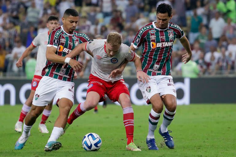 Tomas Portillo of Argentina's Argentinos Juniors vies for the ball with PH Ganso, right, and Andre, of Brazil's Fluminense, during a Copa Libertadores round of 16 second leg soccer match at the Maracana stadium in Rio de Janeiro, Brazil, Tuesday, Aug. 8, 2023. (AP Photo/Bruna Prado)
