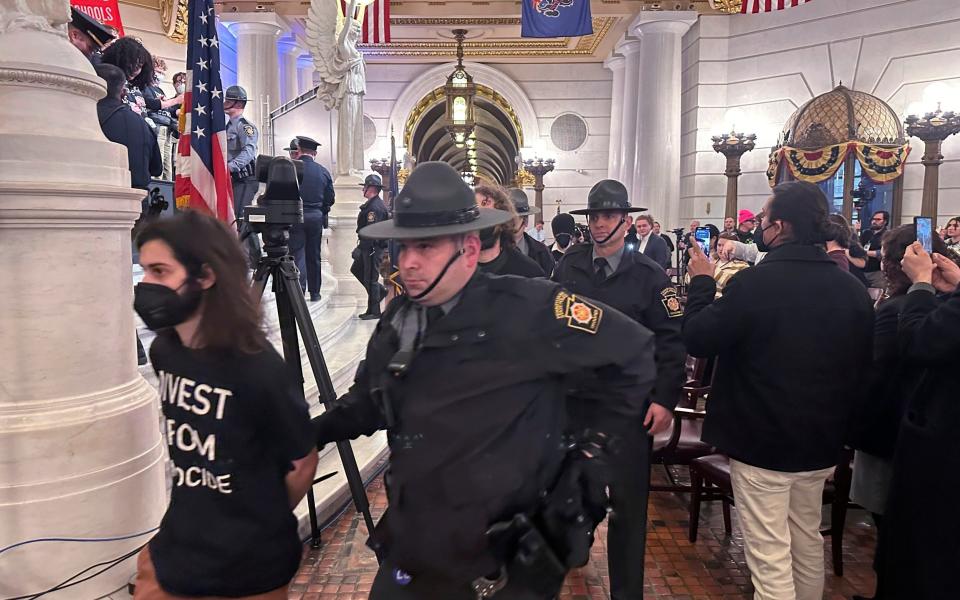 Police arrest protestors at a demonstration against the state Treasury Department's investment in Israel bonds