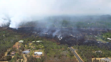 Molten rock flows and burst to the surface, threatening homes in a rural area in this still image from an aerial video taken from a Hawaii Army National Guard a week after the eruption of the Kilauea volcano, in Pahoa, Hawaii, U.S., May 10, 2018. Courtesy Andrew Jackson/Hawaii DoD/Handout via REUTERS