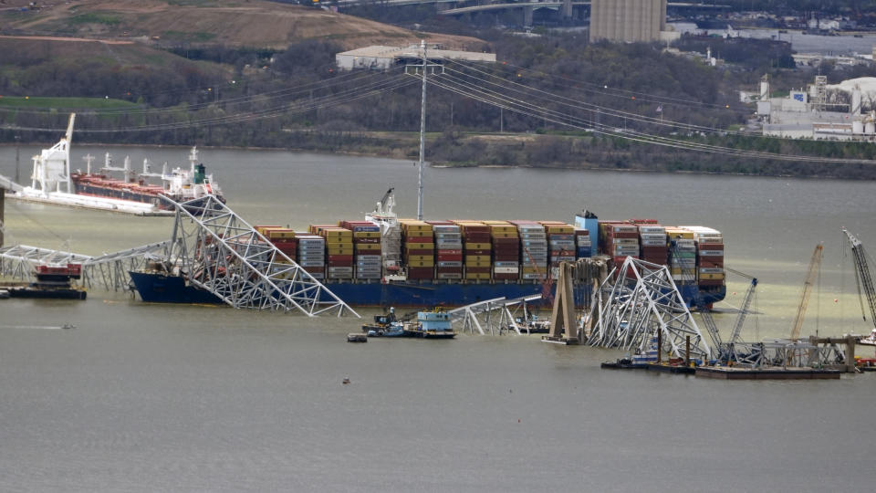 Wreckage of the Francis Scott Key Bridge rests on the container ship Dali, as President Joe Biden takes an aerial tour of the collapsed Francis Scott Key Bridge in Baltimore, Friday, April 5, 2024, as seen from an accompanying aircraft. (AP Photo/Manuel Balce Ceneta)