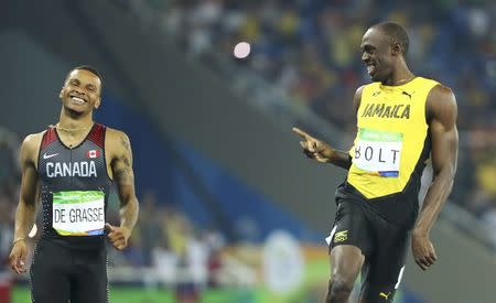 2016 Rio Olympics - Athletics - Semifinal - Men's 200m Semifinals - Olympic Stadium - Rio de Janeiro, Brazil - 17/08/2016. Usain Bolt (JAM) of Jamaica and Andre De Grasse (CAN) of Canada react. REUTERS/Lucy Nicholson