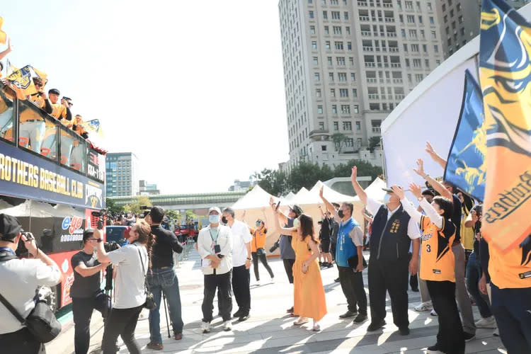 台中市長盧秀燕穿上中信兄弟球衣，向雙層巴士遊街的中信兄弟隊員們揮手。台中市政府提供