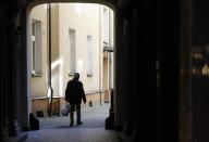 An elderly man returns home with his shopping, which is one of the very few outdoor activities allowed under a national quarantine against the spread of the coronavirus, in Warsaw, Poland, on Thursday, March 26, 2020. The new coronavirus causes mild or moderate symptoms for most people, but for some, especially older adults and people with existing health problems, it can cause more severe illness or death.(AP Photo/Czarek Sokolowski)