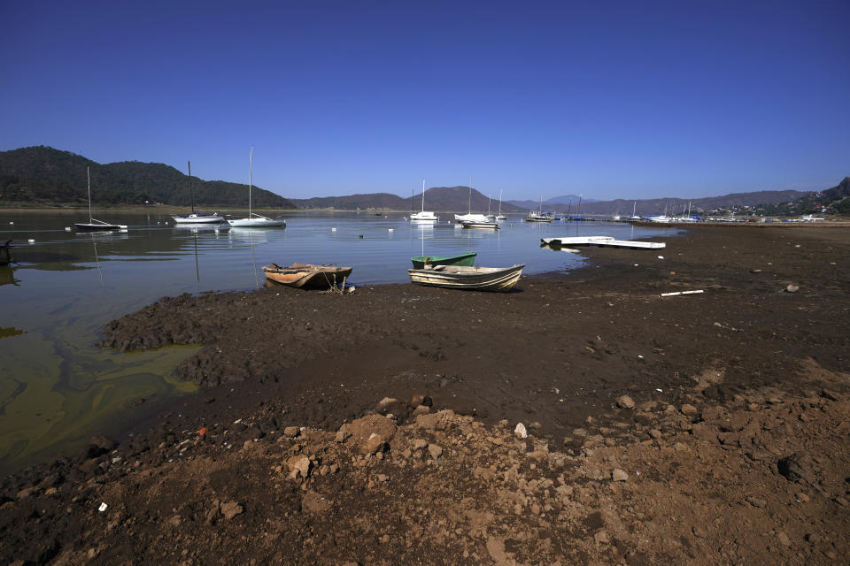 Boats sits on the exposed banks of the Miguel Aleman dam in Valle de Bravo, Mexico, Thursday, March 14, 2024. According to Mexico’s National Water Commission, Valle de Bravo’s reservoir has fallen to 29% of its capacity – a historical low -- compared to one year ago when it was at 52%, while the country endures a drought and has imposed restrictions on water taken from the system. (AP Photo/Marco Ugarte)