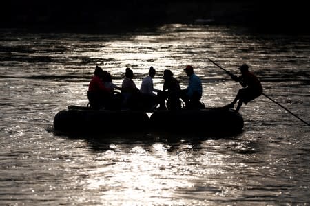 Migrants cross the Suchiate river on a raft from Tecun Uman, in Guatemala, to Ciudad Hidalgo, as seen from Ciudad Hidalgo