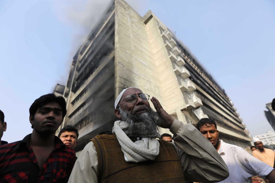 An employee cries in front of a Standard Group garment factory which was on fire in Gazipur