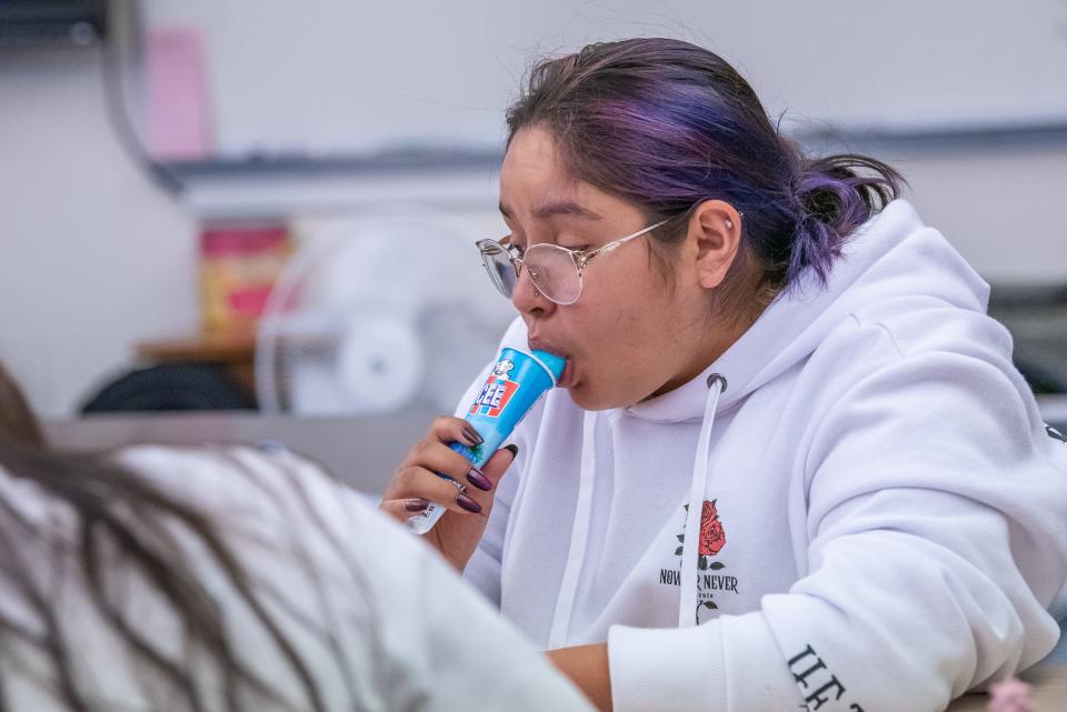 Fort Collins High School student Angelina Dubray-Cosme cools off with an ice pop during an afternoon journalism class Tuesday in Fort Collins. Because the school does not have a working air conditioning system, the second-floor classroom uses four portable fans to circulate air on hot days.