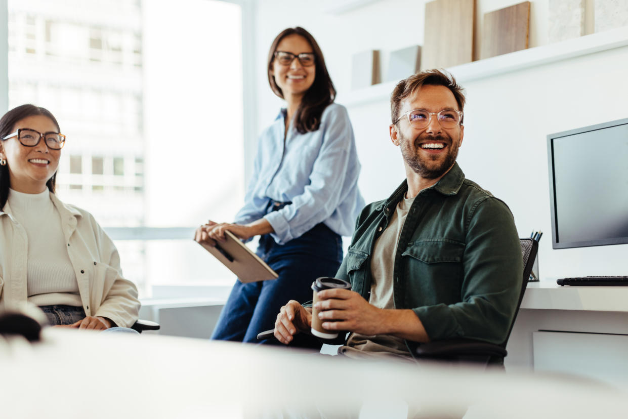 Professionals listening to a discussion in an office. Group of happy business people having a team meeting. health