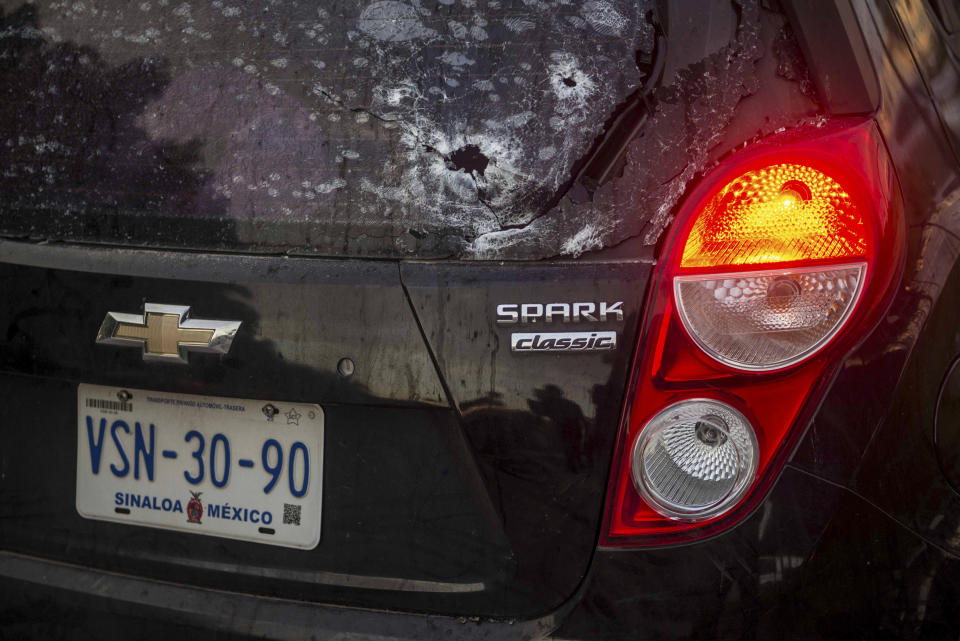 A car's rearview window is pierced with bullet holes amid a gunfight in Culiacan, Mexico, Thursday, Oct. 17, 2019. An intense gunfight with heavy weapons and burning vehicles blocking roads raged in the capital of Mexico’s Sinaloa state Thursday after security forces located one of Joaquín “El Chapo” Guzmán’s sons who is wanted in the U.S. on drug trafficking charges. (AP Photo/Hector Parra)