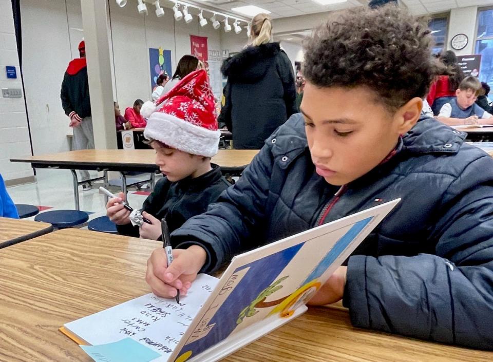 Worley School students Lachlan McIntosh, left, and Da'Vontae Powell sign copies of their new book, "When I Grow Up."