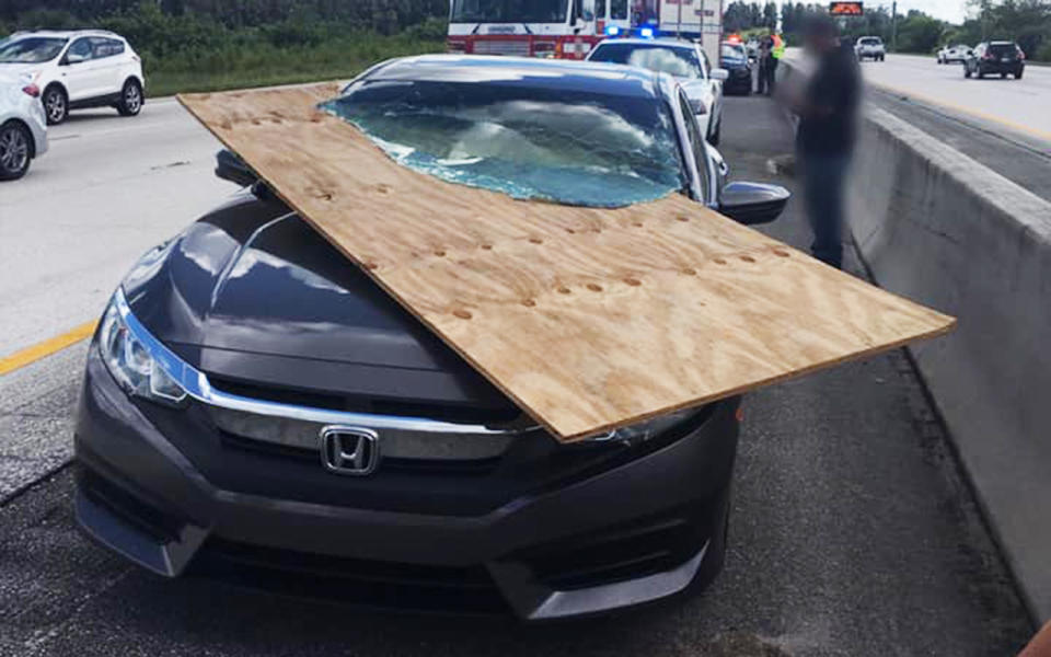 The plywood fell off the back of a flat bed truck and sliced through the Honda’s windshield.Image: Brevard County Fire Rescue