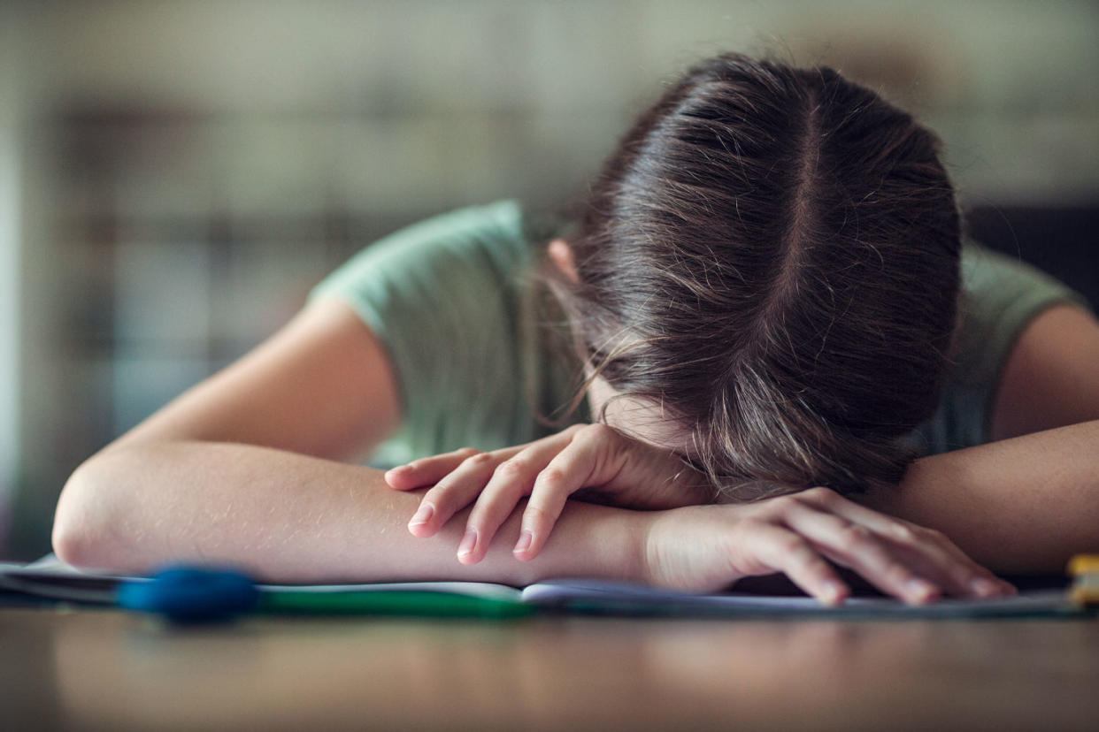 Teenage girl with head in hands, fed up with school homework (Elva Etienne / Getty Images)