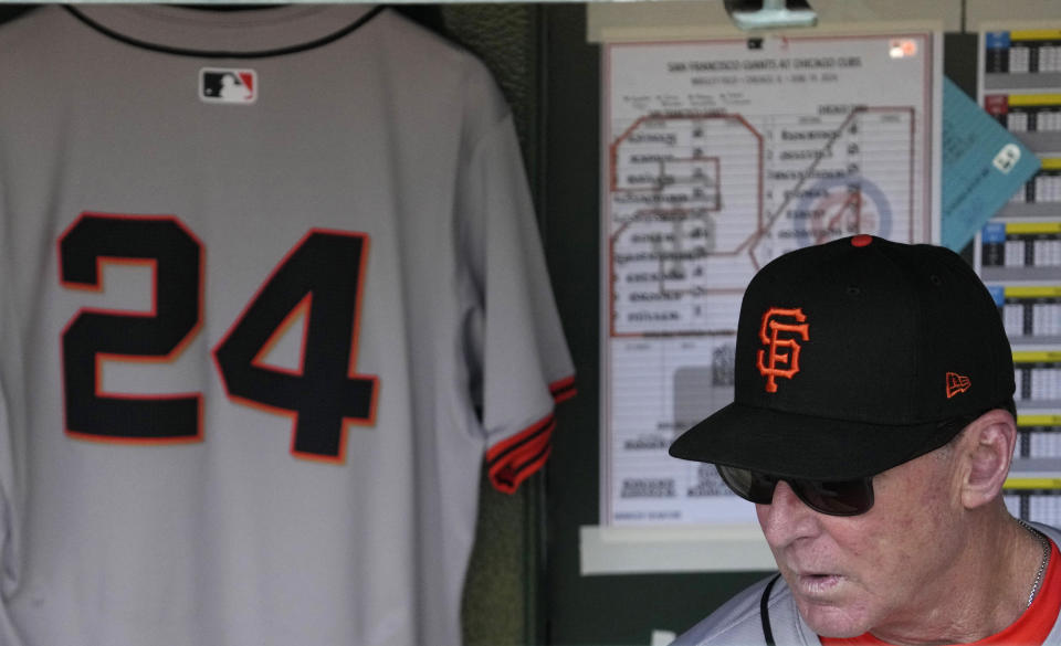 The jersey of former San Francisco Giants player Willie Mays hangs in the dugout as San Francisco Giants manager Bob Melvin looks down before a baseball game against the Chicago Cubs in Chicago, Wednesday, June 19, 2024. (AP Photo/Nam Y. Huh)