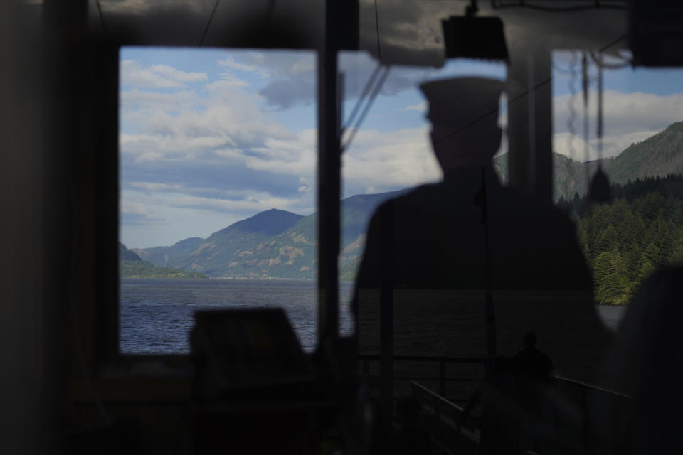 Dennis Moore steers a Columbia River tour boat on Saturday, June 18, 2022, in Cascade Locks, Ore. (AP Photo/Jessie Wardarski)