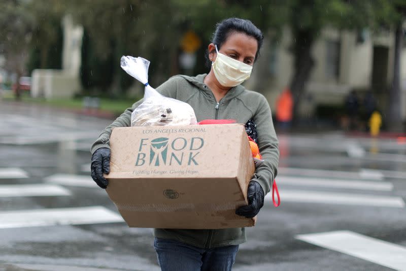 FILE PHOTO: A woman carries away fresh food at a Los Angeles Regional Food Bank giveaway of 2,000 boxes of groceries, as the spread of the coronavirus disease (COVID-19) continues, in Los Angeles