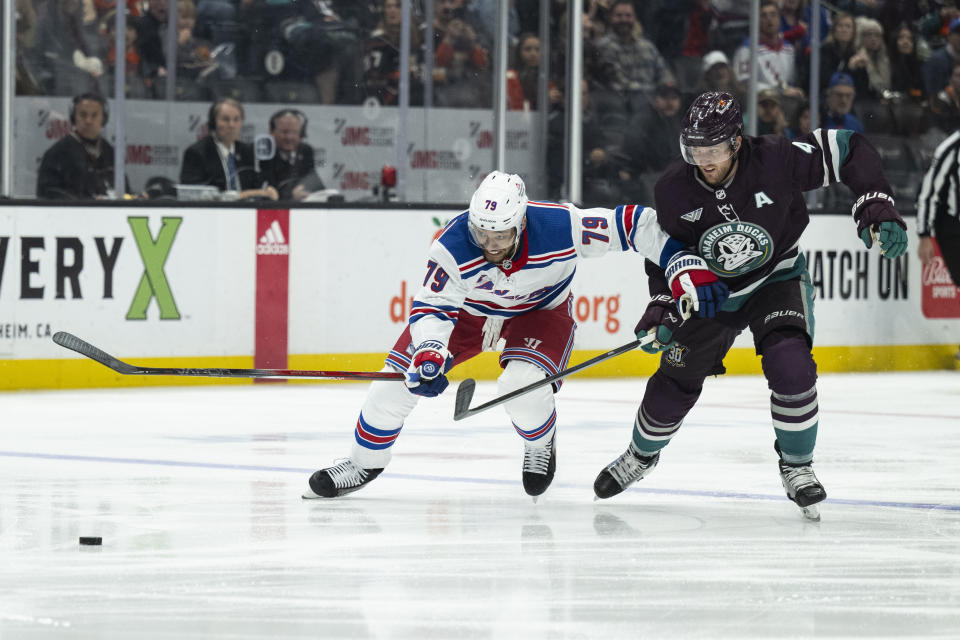 Anaheim Ducks defenseman Cam Fowler (4) and New York Rangers defenseman K'Andre Miller (79) vie for the puck during the second period of an NHL hockey game, Sunday, Jan. 21, 2024, in Anaheim, Calif. (AP Photo/Kyusung Gong)