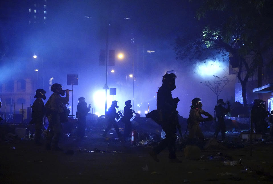 Police in riot gear move into the campus of Hong Kong Polytechnic University in Hong Kong, early Monday, Nov. 18, 2019. Hong Kong police have stormed into a university campus held by protesters after an all-night standoff. Fiery explosions could be seen inside as riot officers entered before dawn Monday. (AP Photo/Vincent Yu)