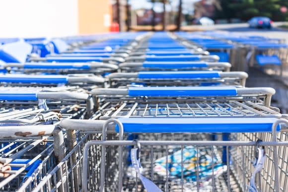 Many rows of blue shopping carts outside a store.