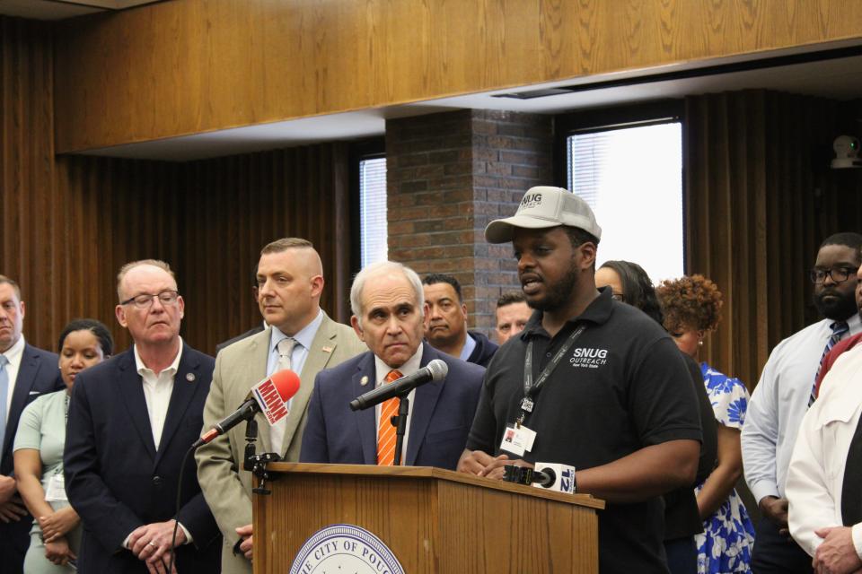From left, State Senator Rob Rolison, Dutchess County District Attorney Anthony Parisi and Assemblyman Jonathan Jacobson, join SNUB Hospital Responder Ivan Braxton, at the podium, Thursday, May 2, 2024 at the Poughkeepsie City Hall Common Council Chambers.