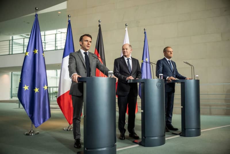 German Chancellor Olaf Scholz (C), French President Emmanuel Macron (L) and Polish Prime Minister Donald Tusk speak during a press statement after the so-called Weimar Triangle meeting. Michael Kappeler/dpa