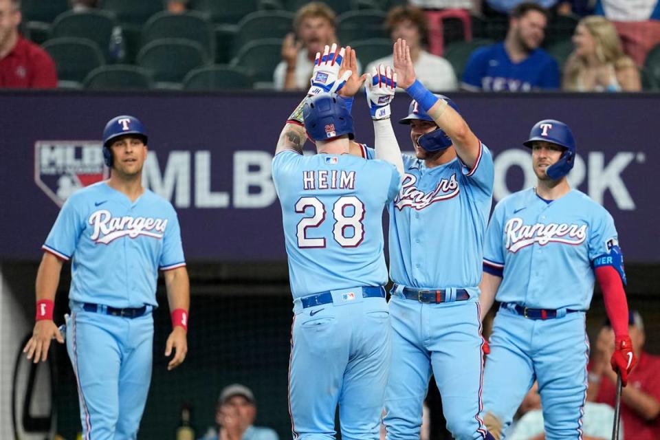 Texas Rangers’ Jonah Heim (28) celebrates with Josh Jung, center right, Nathaniel Lowe, left, and Mitch Garver, right, after hitting a three-run home run in the sixth inning of a baseball game against the Seattle Mariners, Sunday, June 4, 2023, in Arlington, Texas. Lowe and Jung also scored on the shot. (AP Photo/Tony Gutierrez)