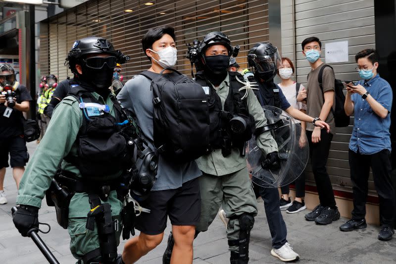 Riot police officers detain a demonstrator during a protest against the second reading of a controversial national anthem law in Hong Kong