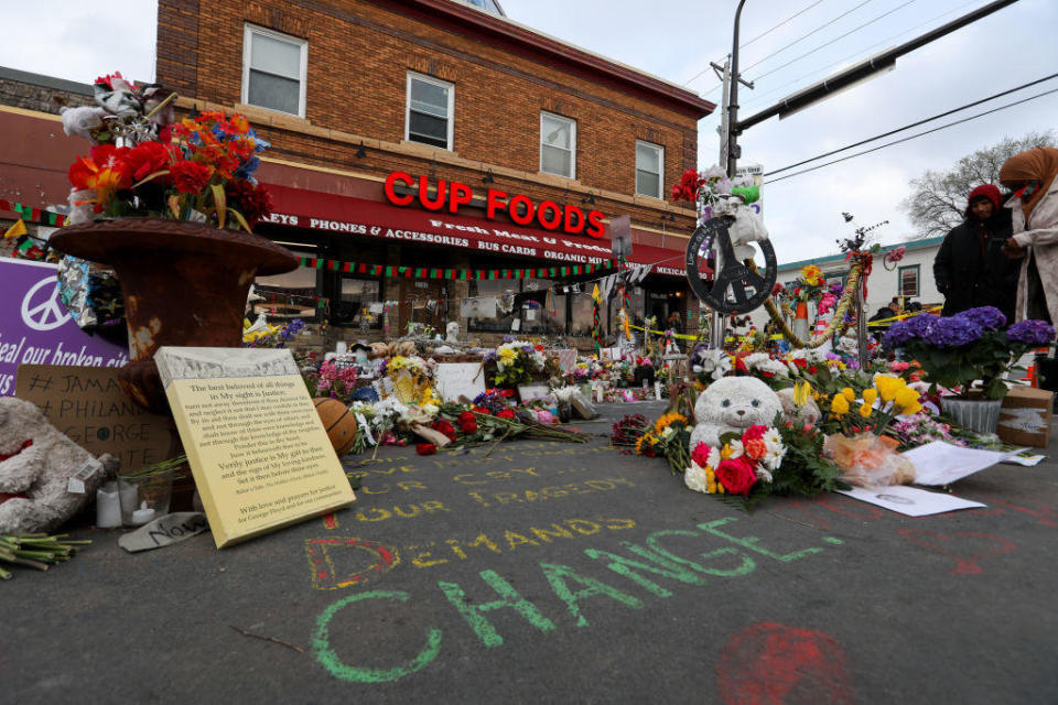 People lay flowers at a memorial in George Floyd Square in Minneapolis on April 21, 2021.  / Credit: Yasin Ozturk/Anadolu Agency via Getty