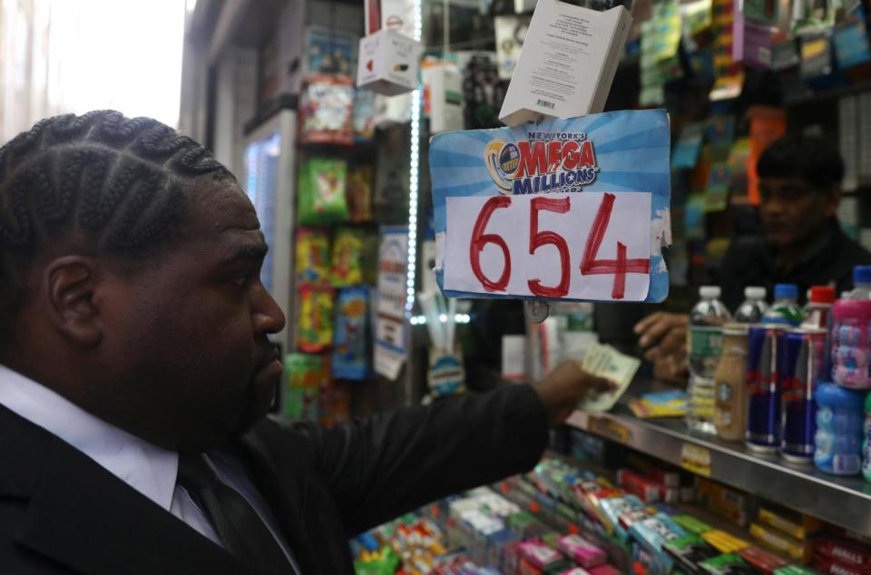 A man buys tickets for the Mega Millions lottery in New York City (REUTERS)