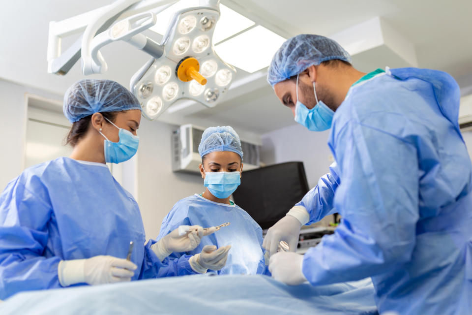 Equipo médico practicando una operación. Imagen vía Getty.