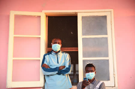 Tuberculosis patients, wearing masks to stop the spread of the disease, stand outside their ward at Chiulo Hospital, Cunene province, Angola February 22, 2018. REUTERS/Stephen Eisenhammer