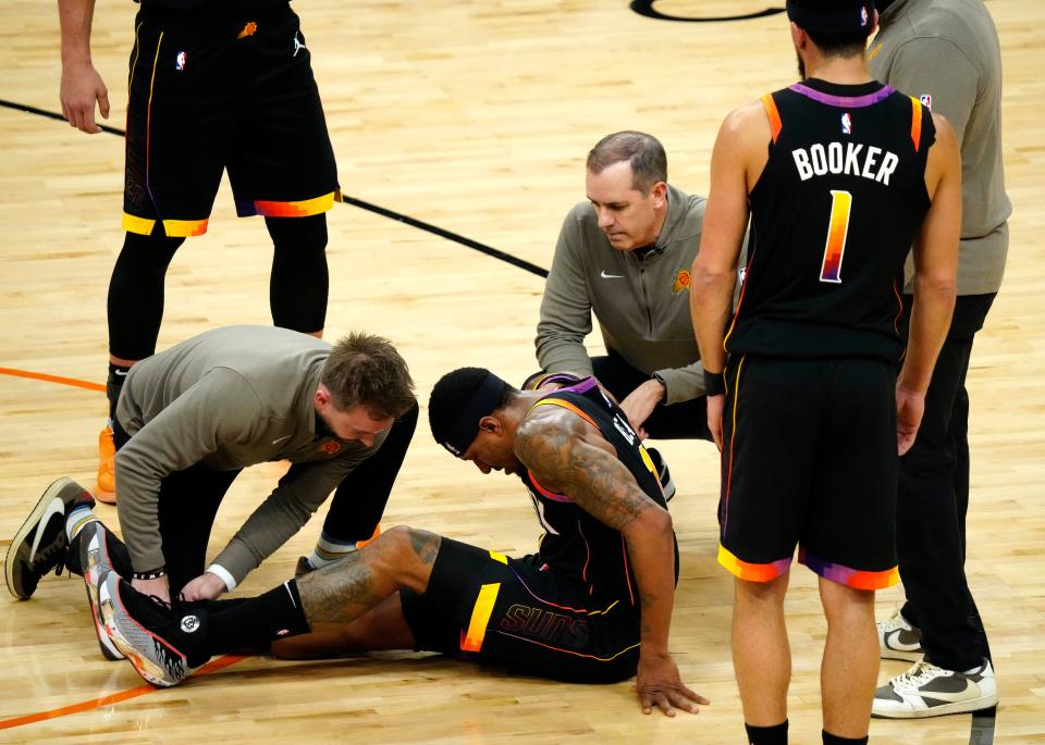 Suns guard Bradley Beal (3) holds his ankle after falling on a made three-pointer being fouled by Donte DiVincenzo during a game at Footprint Center on Dec. 15, 2023.