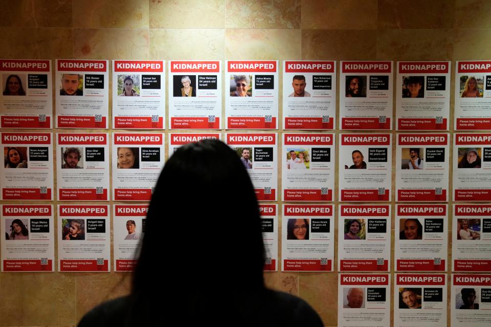 A woman is shown at the Jewish Community Center, in Tenafly, as she looks at flyers of some of the approximate 200 people who were kidnapped on October 7. Wednesday, November 8, 2023