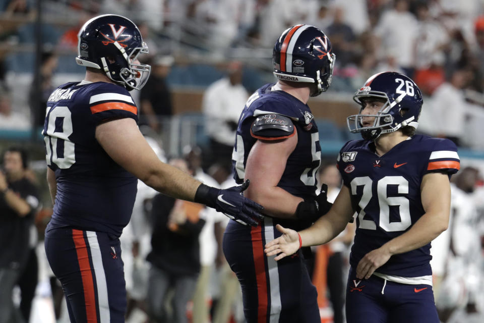 Virginia place kicker Brian Delaney (26) is congratulated by defensive tackle Eli Hanback (58) after making field goal during the first half of an NCAA college football game against Miami, Friday, Oct. 11, 2019, in Miami Gardens, Fla. (AP Photo/Lynne Sladky)