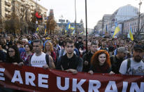 Ukrainians attend a rally marking Defense of the Homeland Day in center Kyiv, Ukraine, Monday, Oct. 14, 2019. Some 15,000 far-right and nationalist activists protested in the Ukrainian capital, chanting "Glory to Ukraine" and waving yellow and blue flags. President Volodymyr Zelenskiy urged participants to avoid violence and warned of potential “provocations” from those who want to stoke chaos. (AP Photo/Efrem Lukatsky)