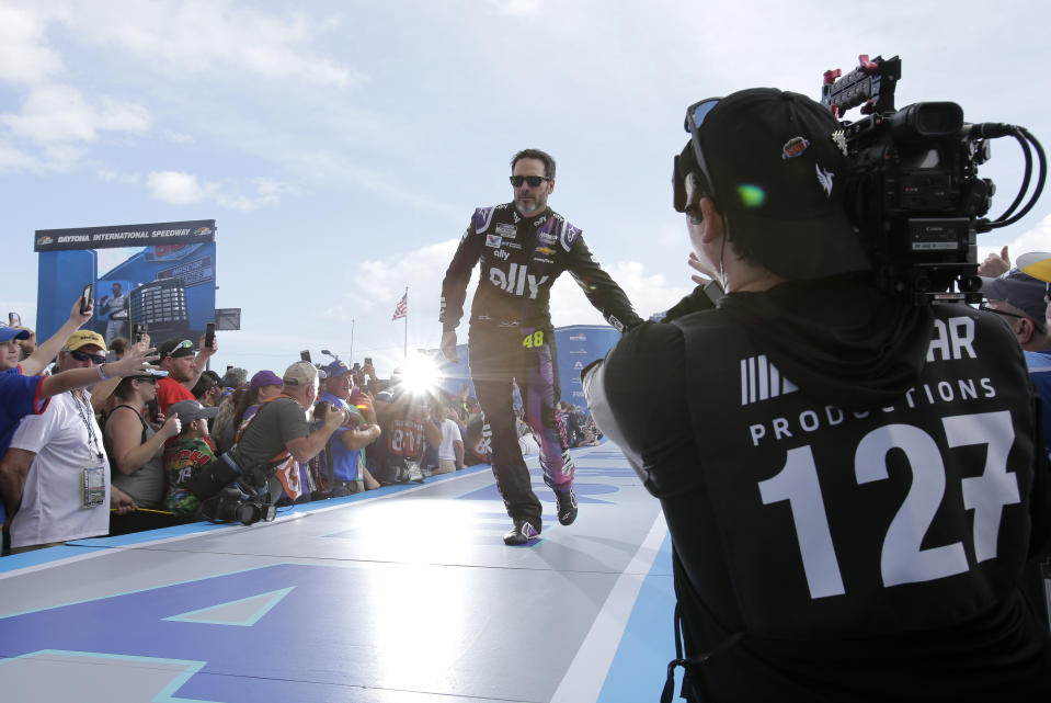 Jimmie Johnson slaps hands with fans during driver introductions before the NASCAR Daytona 500 auto race at Daytona International Speedway, Sunday, Feb. 16, 2020, in Daytona Beach, Fla. (AP Photo/Terry Renna)