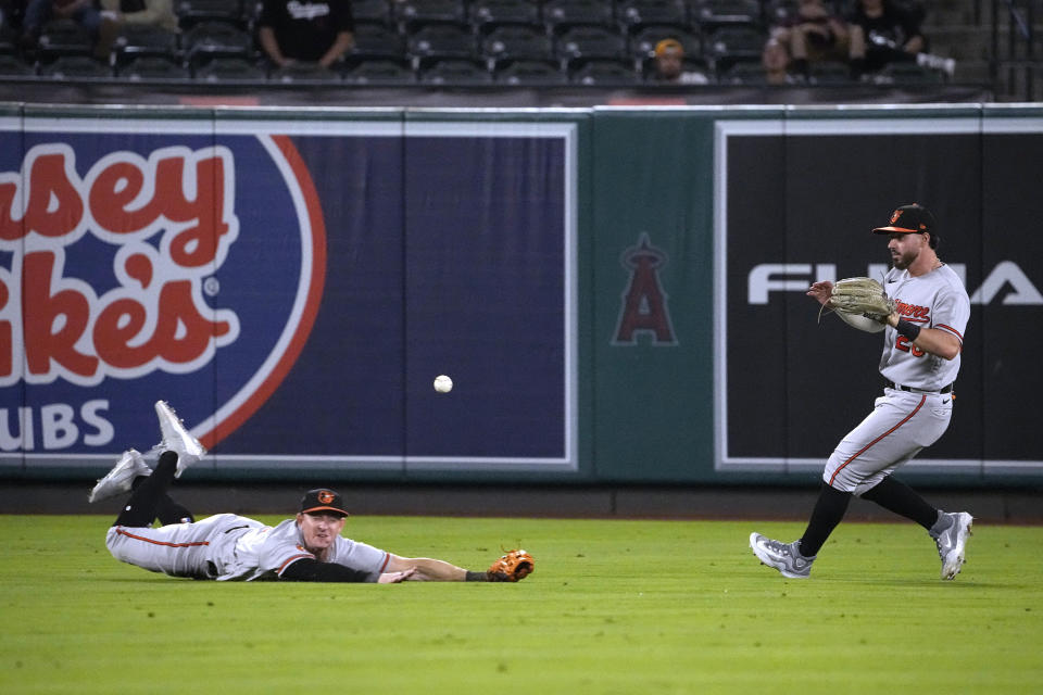 Baltimore Orioles left fielder Austin Hays, left, can't get to a ball hit for a single by Los Angeles Angels' Randal Grichuk as right fielder Ryan McKenna backs him up during the sixth inning of a baseball game Tuesday, Sept. 5, 2023, in Anaheim, Calif. (AP Photo/Mark J. Terrill)
