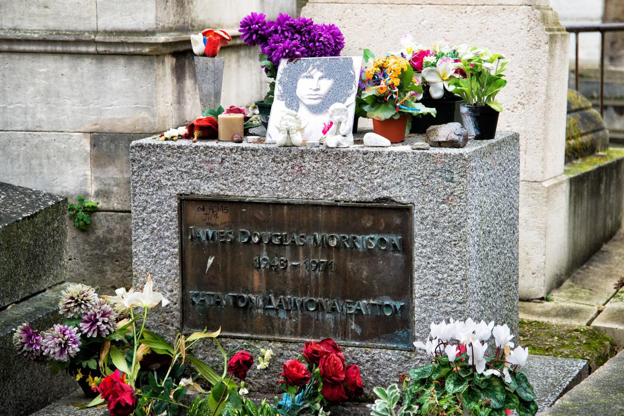 Jim Morrison's grave in the Père Lachaise Cemetery, Paris surrounded by other headstones