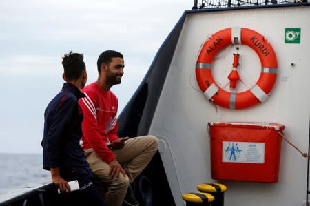 Tunisian migrants react on the German NGO Sea-Eye migrant rescue ship 'Alan Kurdi' after they were informed they would disembark in Malta, in international waters off Malta in the central Mediterranean Sea