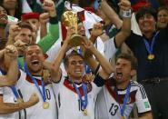 (L-R) Germany's Lukas Podolski, Philipp Lahm, Thomas Mueller and coach Joachim Loew celebrate with the World Cup trophy after the 2014 World Cup final between Germany and Argentina at the Maracana stadium in Rio de Janeiro July 13, 2014. REUTERS/Kai Pfaffenbach