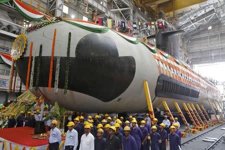 Employees stand in front of the Indian Navy's first Scorpene submarine before being undocked from Mazagon Docks Ltd, a naval vessel ship-building yard, in Mumbai April 6, 2015. REUTERS/Shailesh Andrade/Files