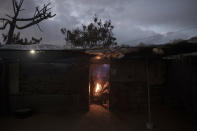 A Palestinian family warm themselves by a fire during a cold weather spell in a slum on the outskirts of the Khan Younis refugee camp, southern Gaza Strip, Wednesday, Jan. 19, 2022. (AP Photo/Khalil Hamra)