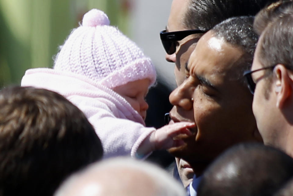 President Barack Obama holds a baby as he meets greeters on the tarmac upon his arrival at the 171st Air Refueling Wing at the Pennsylvania Air National Guard base in Coraopolis, Pa., Wednesday, April 16, 2014. Obama joined Vice President Joe Biden in the Pittsburgh area to speak at a nearby community college about job training grants. (AP Photo/Keith Srakocic)