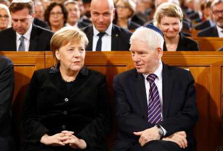 German Chancellor Angela Merkel speaks with President of the Central Council of Jews in Germany Josef Schuster as they take part in a ceremony to mark the 80th anniversary of Kristallnacht, also known as Night of Broken Glass, at Rykestrasse Synagogue, in Berlin, Germany, November 9, 2018. REUTERS/Fabrizio Bensch